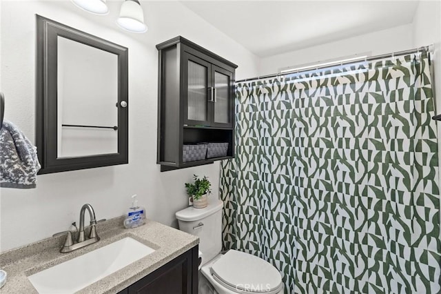 bathroom featuring a shower with shower curtain, toilet, and vanity