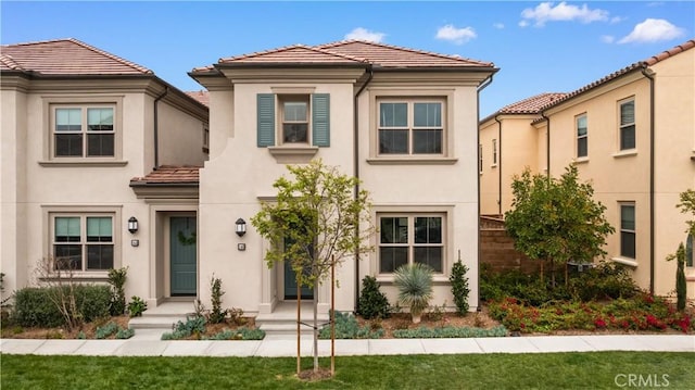 mediterranean / spanish-style house with stucco siding and a tiled roof