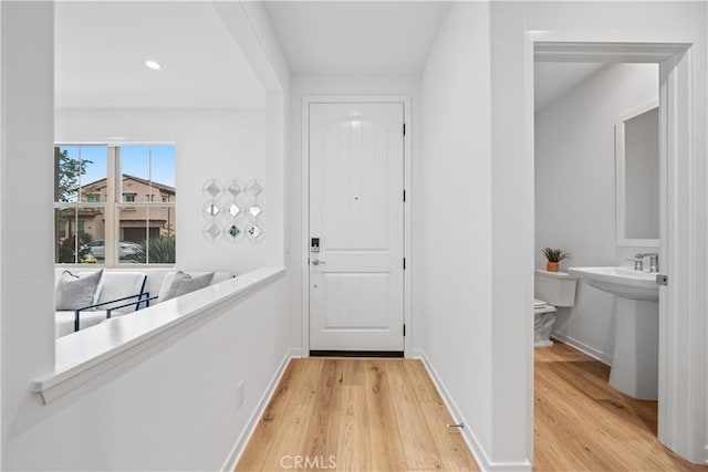 entryway with light wood finished floors, recessed lighting, and baseboards