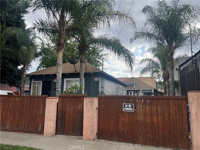 view of front of home with a fenced front yard and a gate