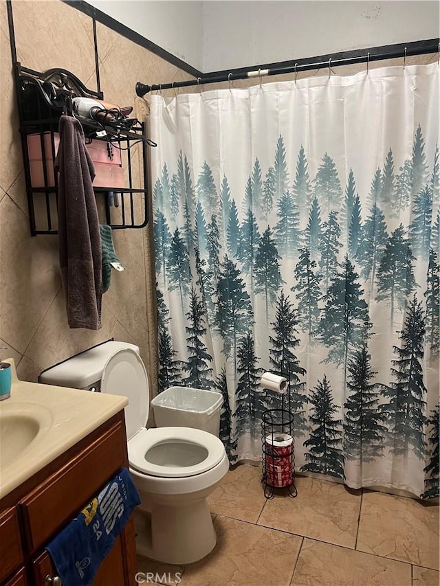 bathroom with tile walls, a shower with curtain, vanity, and toilet