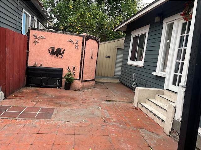 view of patio with entry steps and fence