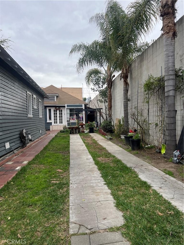 view of yard featuring french doors and fence