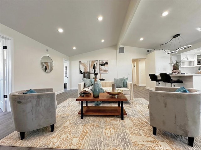 living room featuring vaulted ceiling with beams, light wood-style flooring, visible vents, and baseboards