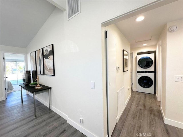 hallway featuring stacked washer / drying machine, visible vents, and wood finished floors