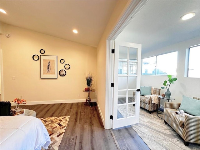 bedroom featuring lofted ceiling, recessed lighting, wood finished floors, and baseboards