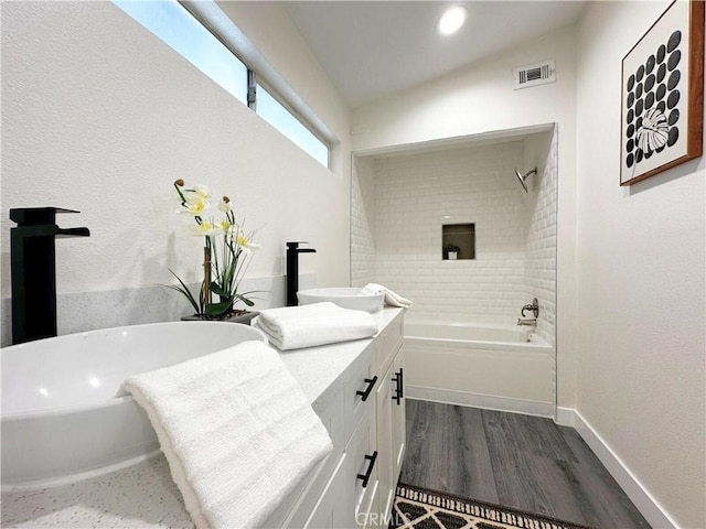 bathroom with baseboards, visible vents, bathing tub / shower combination, wood finished floors, and vanity