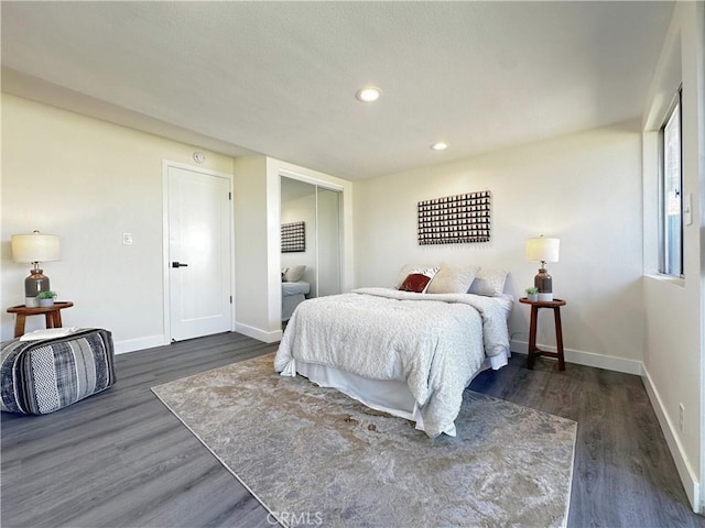 bedroom with dark wood-style flooring, recessed lighting, a closet, and baseboards