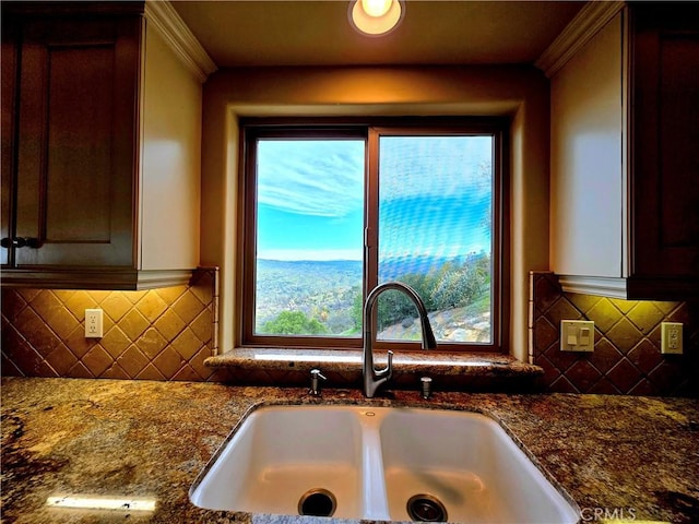 interior details featuring dark stone countertops, a sink, and decorative backsplash