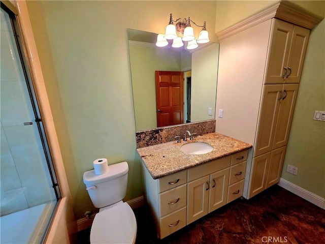 bathroom featuring combined bath / shower with glass door, vanity, toilet, and baseboards