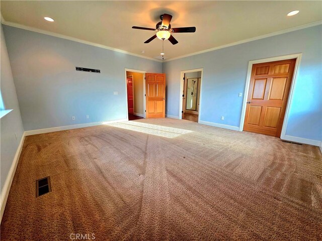 unfurnished bedroom featuring carpet floors, visible vents, ornamental molding, and baseboards