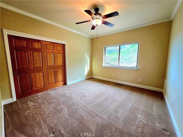 unfurnished bedroom featuring crown molding, carpet, visible vents, and baseboards