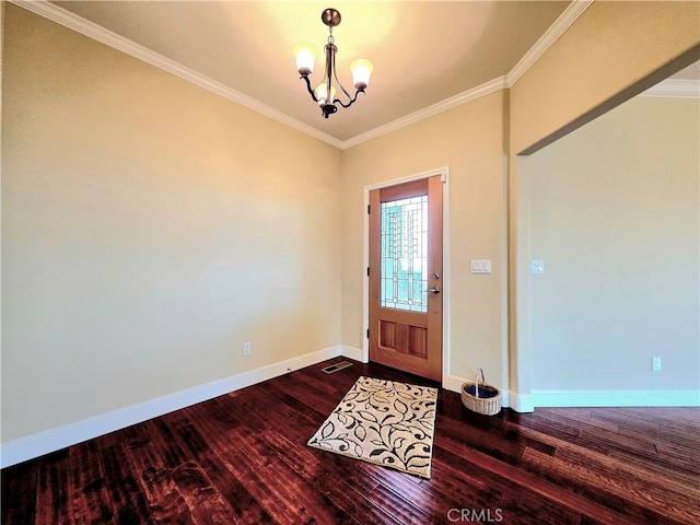 entrance foyer featuring dark wood-style floors, ornamental molding, a chandelier, and baseboards