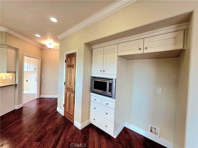 kitchen featuring baseboards, visible vents, stainless steel microwave, ornamental molding, and dark wood-style flooring