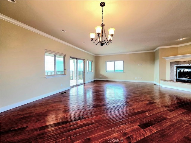 unfurnished living room featuring visible vents, a notable chandelier, baseboards, and wood finished floors