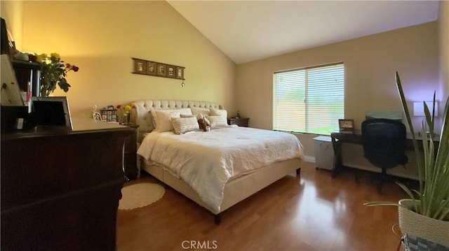 bedroom with lofted ceiling and wood finished floors