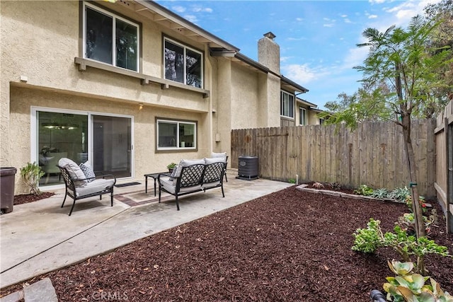 rear view of property featuring a fenced backyard, a patio, and stucco siding