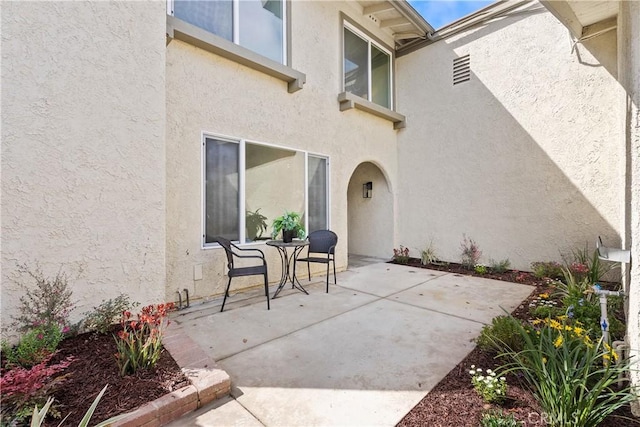 doorway to property with a patio and stucco siding