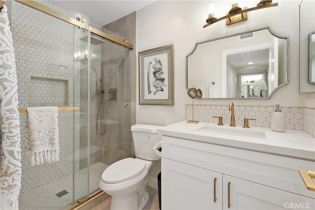 full bathroom with vanity, a stall shower, backsplash, and toilet