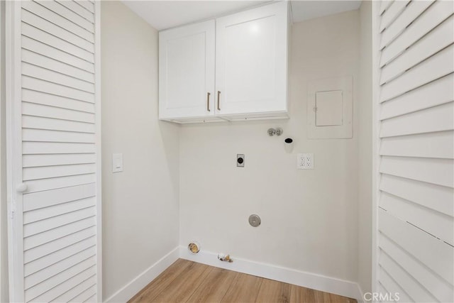 laundry area featuring cabinet space, light wood finished floors, baseboards, gas dryer hookup, and electric dryer hookup