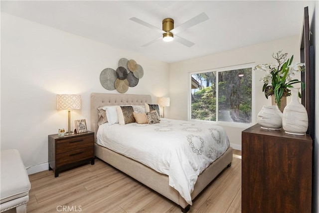 bedroom with light wood-style flooring, baseboards, and ceiling fan