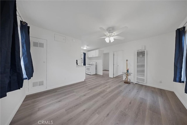 empty room with baseboards, light wood-style flooring, visible vents, and a ceiling fan