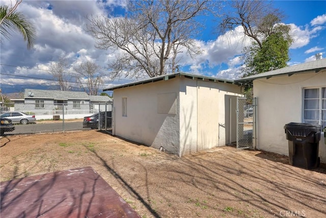 view of side of home featuring fence and stucco siding