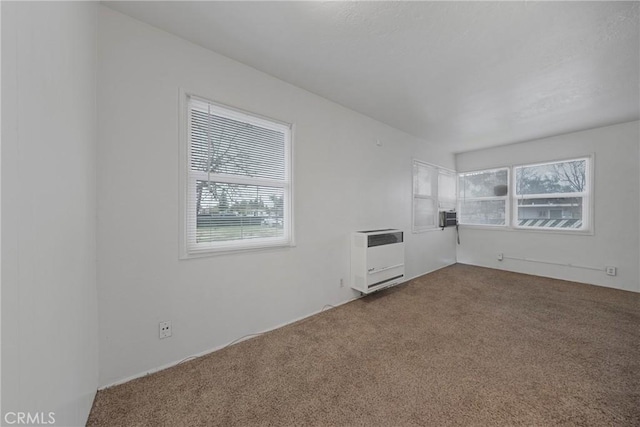 empty room featuring carpet floors and heating unit