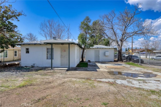 back of property featuring fence and stucco siding