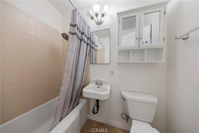 bathroom featuring baseboards, a sink, toilet, and shower / tub combo with curtain