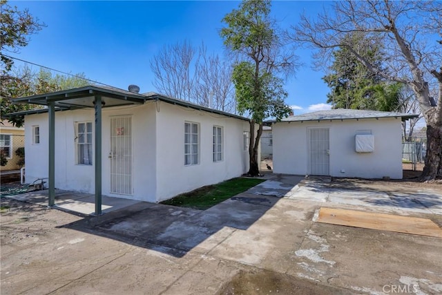 view of property exterior with an outdoor structure and stucco siding