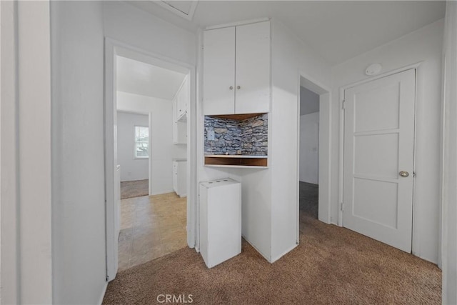 kitchen featuring light carpet and white cabinetry