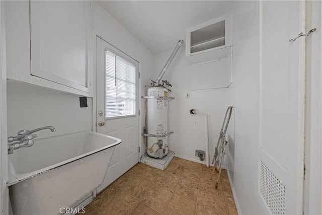 clothes washing area featuring cabinet space, water heater, light tile patterned floors, and a sink