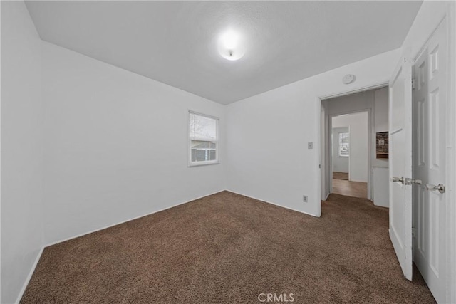 empty room with dark colored carpet