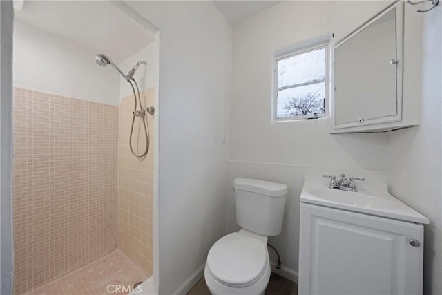 full bath with toilet, tiled shower, and vanity