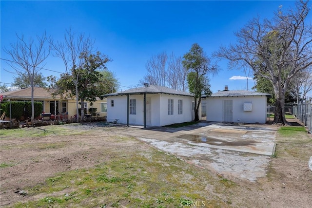 rear view of house with fence and stucco siding