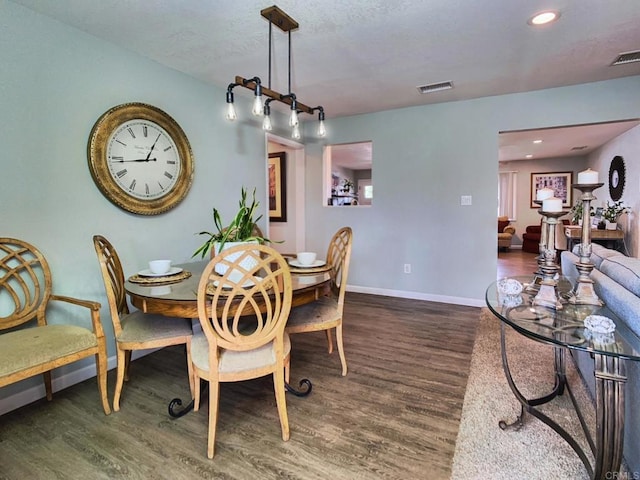 dining area featuring baseboards, visible vents, wood finished floors, and recessed lighting