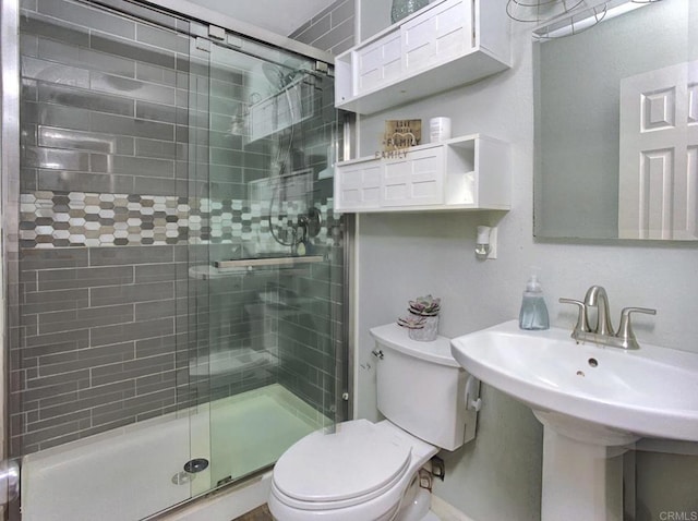 full bath with a stall shower, a sink, and toilet