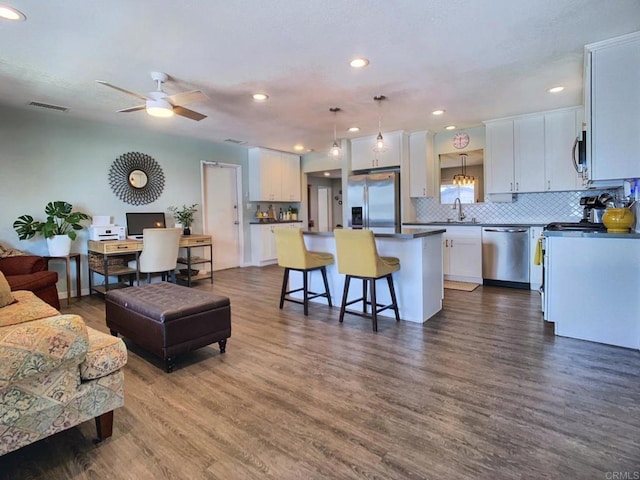 living area featuring dark wood-style floors, recessed lighting, visible vents, and a ceiling fan