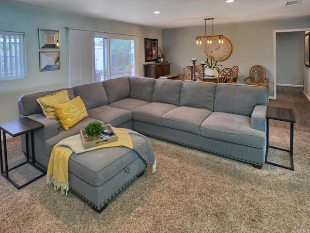 living room featuring an inviting chandelier, baseboards, wood finished floors, and recessed lighting