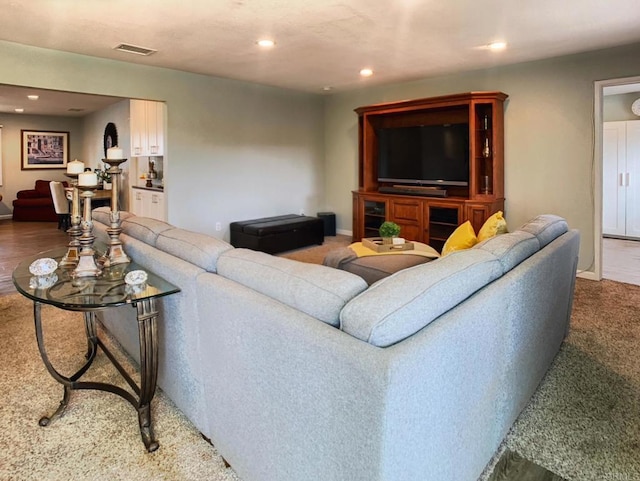 carpeted living area with visible vents and recessed lighting