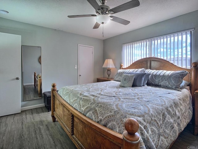 bedroom with a ceiling fan, a textured ceiling, baseboards, and wood finished floors