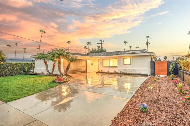 ranch-style house with a front lawn, fence, stucco siding, stone siding, and an attached garage