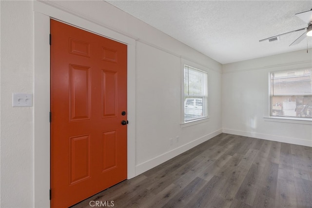 entryway with visible vents, a textured ceiling, baseboards, and wood finished floors