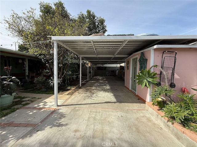 view of parking featuring a carport and concrete driveway