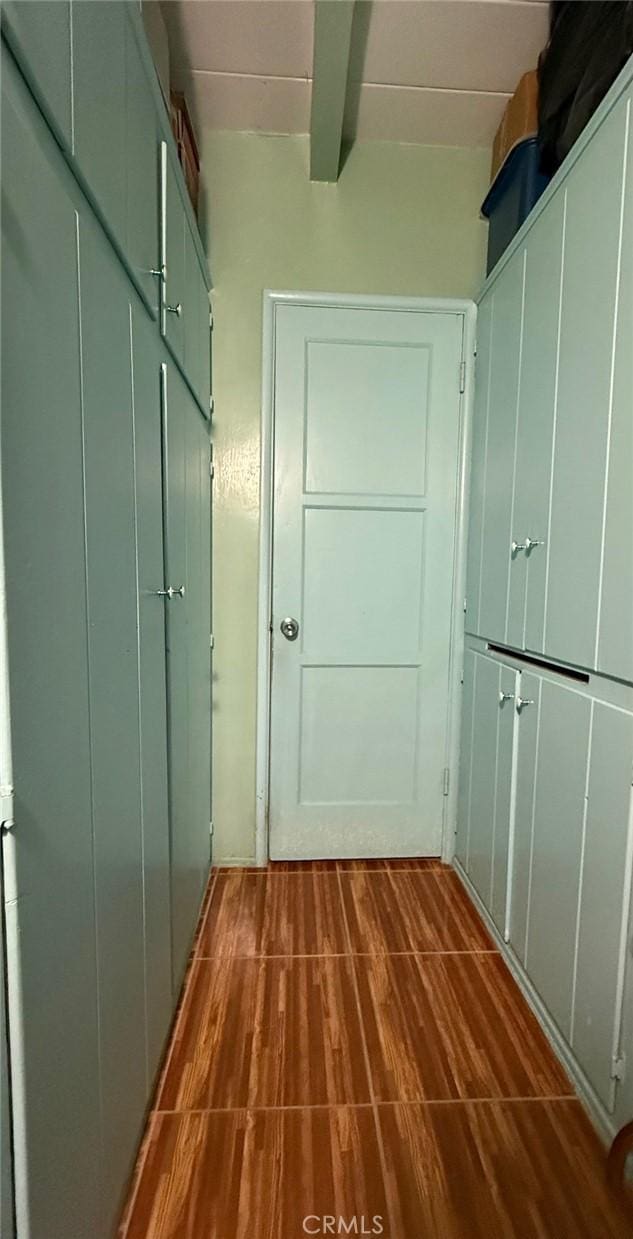 corridor with beamed ceiling and dark wood finished floors