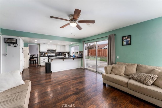 living area with a ceiling fan, recessed lighting, and dark wood-style flooring