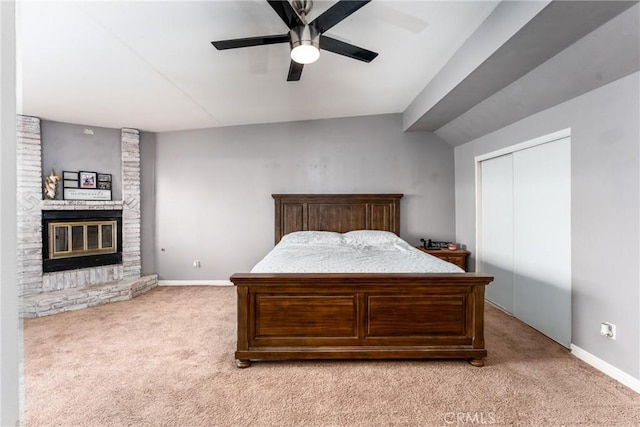 bedroom featuring light carpet, a brick fireplace, ceiling fan, and baseboards