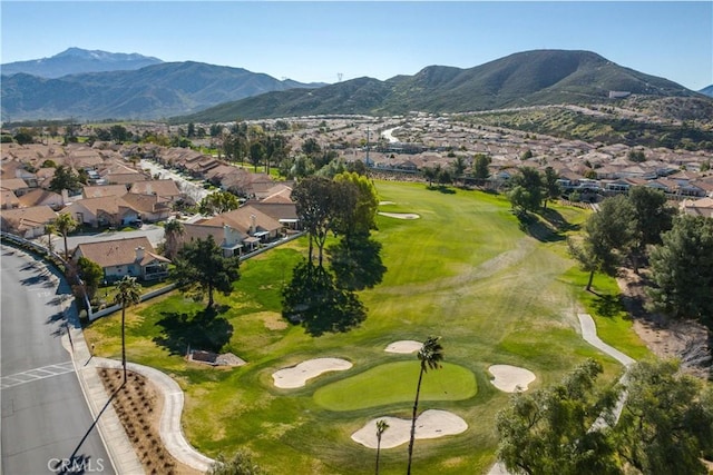 drone / aerial view with a residential view, a mountain view, and golf course view