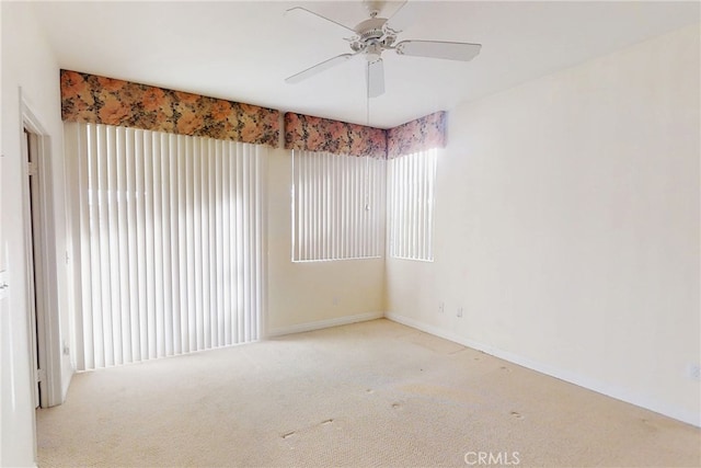 unfurnished room with carpet, a ceiling fan, and baseboards